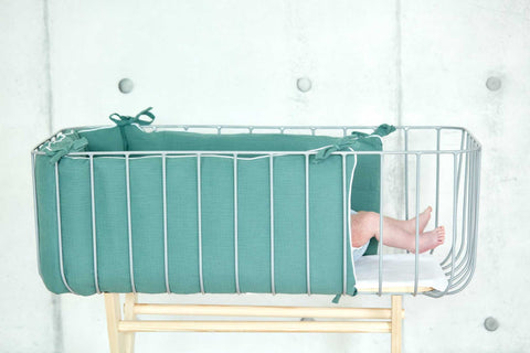 Bettumrandung aus Musselin in Nilblau im Babybett.