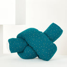 Eine Wickeltischrolle Musselin goldene Punkte auf Petrol von KraftKids GmbH ruht vor einem minimalistischen weißen Hintergrund mit geometrischen Formen.