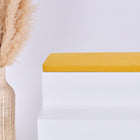 Eine hohe geflochtene Vase mit beigem Pampasgras steht neben einem weißen Stufenpodest, das mit der KraftKids GmbH Sitzauflage für Ikea TROFAST Doppelkrepp Gelb Senf vor einem schlichten hellen Hintergrund gekrönt wird.