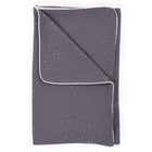 Eine gefaltete Babydecke Musselin goldene Punkte auf Grau von KraftKids, mit kleinen goldenen Punkten und weißer Paspelierung auf weißem Hintergrund.