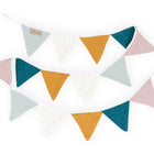 Die KraftKids Wimpelkette goldene Punkte auf Musselin besteht aus zwei Reihen pastellfarbener dreieckiger Fähnchen - rosa, hellblau, senfgelb, weiß mit goldenen Punkten und dunkelgrün - in einem abwechselnden Muster für eine charmante Kinderzimmer-Deko.