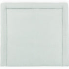 Eine weiche, grüne, rechteckige KraftKids Wickelauflage Musselin Babymatte mit einem gepolsterten Rand und einem kleinen goldenen Punktmuster. Verfügt über ein einfaches, minimalistisches Design, das plüschig und bequem wirkt.