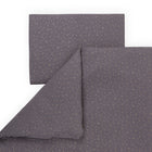 Das KraftKids Bettwäscheset zeigt sich in Grau mit dezent goldenen Punkten und ist ordentlich gefaltet auf weißem Hintergrund präsentiert.