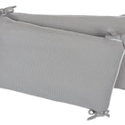 Die KraftKids Bettumrandung Nestchen Waffel Piqué grau ist handgefertigt aus 100% Baumwolle, zeigt ein strukturiertes Muster und liegt schräg gestapelt vor weißem Hintergrund.