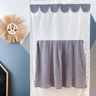 An der Wand eines Kinderzimmers hängen ein Strohlöwe, das KraftKids Puppentheater Kasperletheater Musselin grau Punkte inkl. Teleskopstange. Teleskopstange in weiß und grau gepunktet, und eine Kreidetafel mit bunten Zeichnungen in der Ecke.